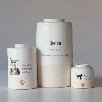 Three white urns with personalized inscriptions on a gray background