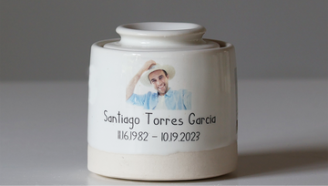 A gloss white ceramic urn with a custom photo and text, designed for adult cremation.
